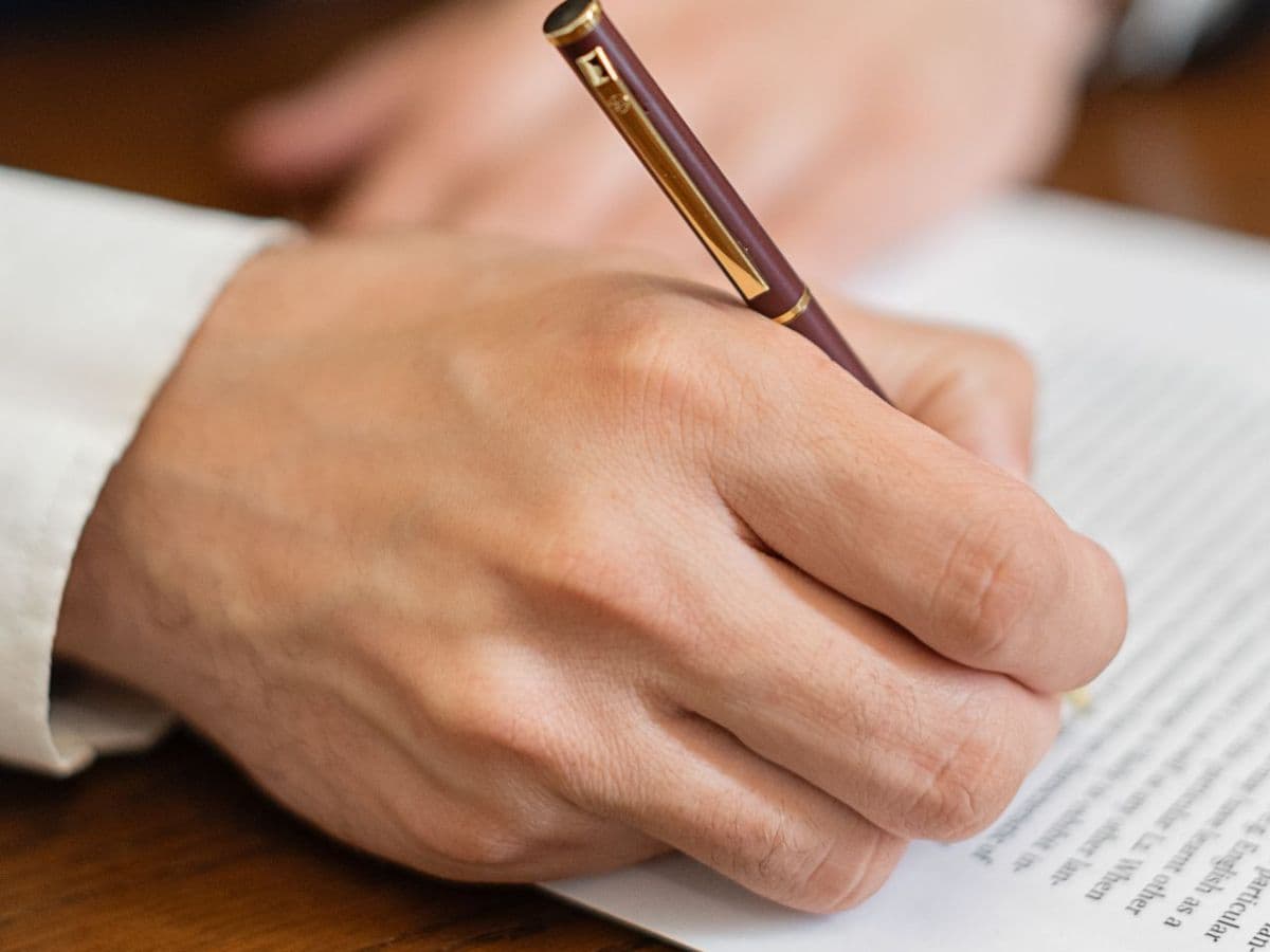 Hand signing a translation certification with a pen on the document