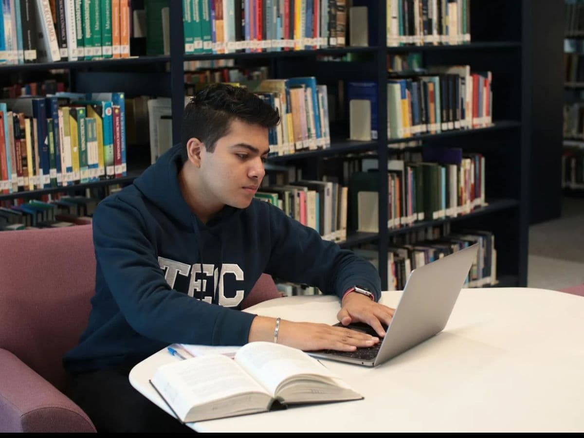 Student working on a laptop in a university library