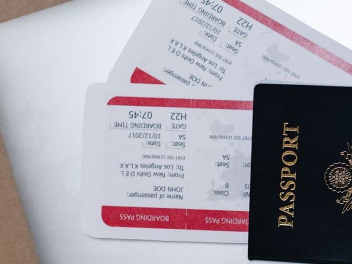 Tarjetas de embarque y pasaporte sobre un portátil, documentos de un viaje internacional